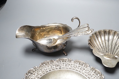 A late Victorian silver butter shell, a later silver sauceboat, seven assorted silver teaspoons including Scottish and two continental white metal dishes(a.f.), gross 16.5oz.